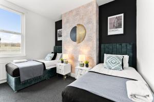 谢菲尔德Spacious and Stylish House - Sleeps 12的一间卧室配有两张床和镜子