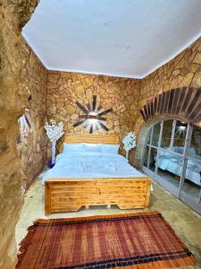 达纳DanaBlack iris house的一间卧室设有一张床和石墙