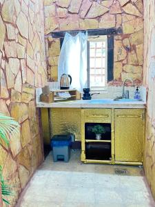 达纳DanaBlack iris house的厨房配有柜台和石墙水槽