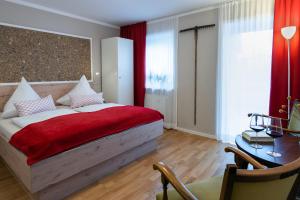 里姆斯廷格Gästehaus Nigglhof的一间卧室配有一张带红色毯子的床