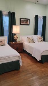 TitusvilleJosephine's Bed & Breakfast的绿窗帘间内的两张床