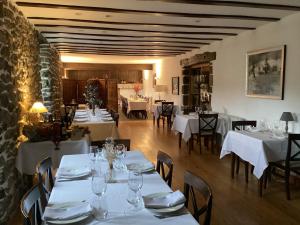 奥尼亚特Goiko-Benta Ostatua的餐厅配有桌椅和白色的桌布