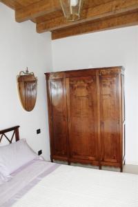 布雷西亚拉费兰达酒店的卧室配有木制橱柜,位于床边