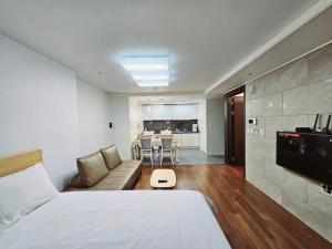 釜山Ciel de Mer的一间卧室配有一张床和一张沙发,还设有一间厨房