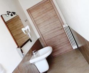 布雷西亚拉费兰达酒店的一间带白色卫生间和木门的浴室