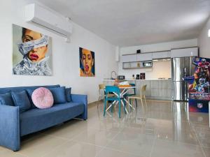 阿雷西博Centrally located Villa with 3 Pools -Food & Beach walking distance的一间带蓝色沙发的客厅和一间厨房