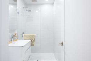 纽约62-2B NEW Prime UES W D in unit的带淋浴和盥洗盆的白色浴室