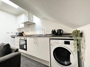 伊肯斯顿Charming 2-Bedroom Oasis的厨房配有洗衣机和水槽