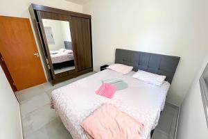 帕图斯迪米纳斯103 - Apartamento Completo Para Até 5 Hóspedes的一间卧室配有带粉红色毛巾的床