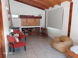 拉安戈斯图拉镇Antares的客厅配有红色椅子和壁炉
