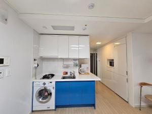 釜山Ciel de Mer的厨房配有白色橱柜和洗衣机。
