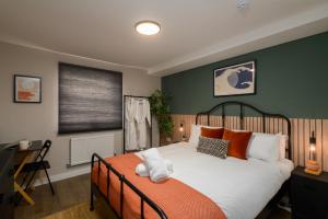卡迪夫Benjamin Suite by Koya Homes - 3 Bedrooms - Cardiff的卧室配有带橙色枕头的大型白色床