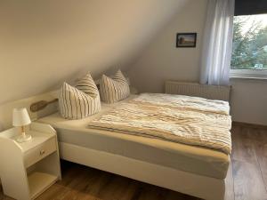 特拉森海德Strandkojen的卧室配有带枕头的床铺和窗户。