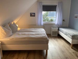特拉森海德Strandkojen的一间卧室设有两张床和窗户。