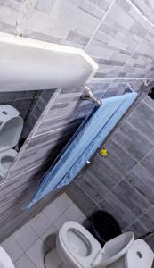 杜阿拉RAMS ENG ROME appartement meublé的浴室设有2个卫生间、水槽和蓝色床单