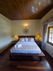 努沃勒埃利耶The Loris Manor的一间卧室设有一张带木制天花板的大床