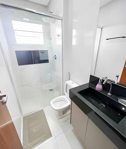 帕图斯迪米纳斯M203- Apartamento c/ Suíte Completo Patos de Minas的带淋浴、盥洗盆和卫生间的浴室
