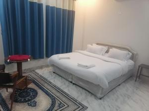 MisfāhJabal Shams bayt kawakib的卧室配有白色床和蓝色窗帘