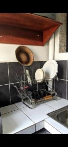 杜阿拉RAMS ENG ROME appartement meublé的厨房里带盘子和盘子的晾衣架