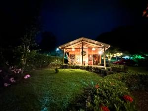 圣拉蒙Romantic Private Cabin in the Forest, Bungalows Tulipanes的温室在晚上点燃,院子照亮