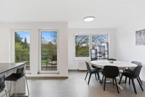 卢森堡Tranquil Haven - Relax and Unwind in Hamm ID23的白色的客房配有桌椅和窗户。