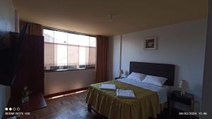 塔克纳Montecristo Hotel的一间卧室设有一张床和一个大窗户
