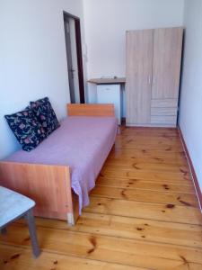 什切青Hostel Tulip - Pokój 7 ze wspólną łazienką i kuchnią的一间卧室配有一张床,铺有木地板