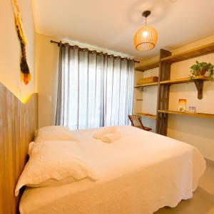 邦比尼亚斯Residencial Mãe terra的卧室配有一张大白色床和窗户