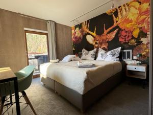 佩尔蒂绍Two Brothers Inn的卧室配有一张大床,墙上挂着鹿头