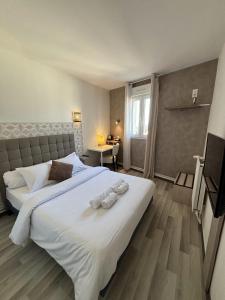 欧特维尔－隆普内斯Hôtel-Restaurant Le Hauteville的卧室配有带毛巾的大型白色床