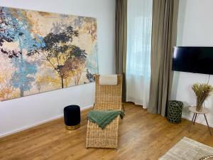 艾森纳赫discovAIR Eisenach - 3-Zi- Apartment Matteo- Schwimmbad-Nah mit Netflix的客厅配有椅子和墙上的绘画