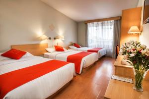 普诺Lake Titicaca Hotel的酒店客房带两张床和花瓶