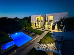 科苏梅尔Villas Mar Turquesa Cozumel的一座晚上设有游泳池的房子
