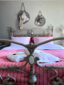 卡尔派尼西翁Petrameli的一间卧室配有带粉色床单和粉红色枕头的床。