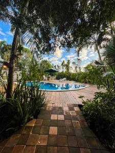 伊塔乌纳斯Vila Cizinho的棕榈树度假村内的游泳池
