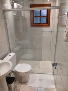 格拉玛多Apto Dom Victor 101的一间带卫生间和玻璃淋浴间的浴室