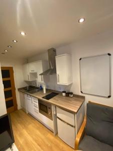 BansteadStudio apartment near Sutton, Croydon的厨房配有白色橱柜和墙上的黑板