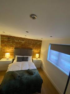 BansteadStudio apartment near Sutton, Croydon的一间卧室设有一张床和砖墙