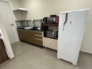 马蒂尼奥斯Condomínio Kaimã的厨房配有冰箱和微波炉。