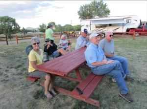 南福克Ute Bluff Lodge, Cabins and RV park的一群人坐在野餐桌旁