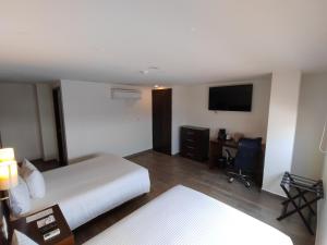 坦皮科Ramada by Wyndham Tampico Centro的酒店客房,配有床和电视