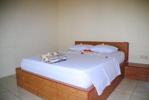 佩母德兰库布纱丽住宿加早餐旅馆的一间卧室配有一张带木制床头板的床和一张带白色床铺的卧室。