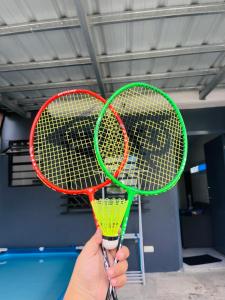 PandiHideout Airbnb的在一个房间里拿着两枚网球拍的人