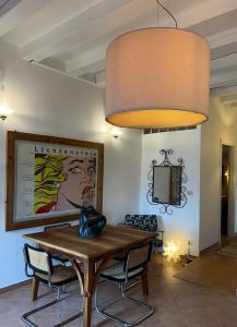 威尼斯Biennale Apartment Venice的一间设有桌子和大灯具的用餐室