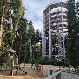 伏尔塔瓦河畔利普诺U Macháčků - Lipno的一座带滑梯的建筑前的游乐场