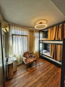 伊斯坦布尔Nomad Hostel Karaköy的客房设有带双层床和椅子的卧室。