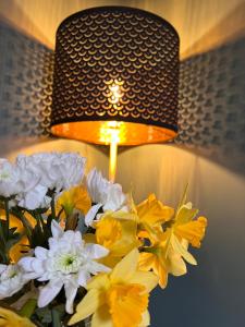 什鲁斯伯里Entire ground floor town flat - Fully equipped and stunning.的灯,花朵呈黄色和白色