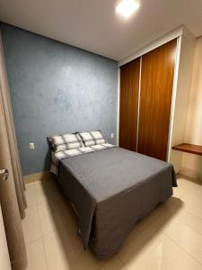 帕尔马斯Casa Impecável的一间卧室设有一张床和蓝色的墙壁