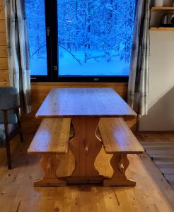 阿卡斯洛姆波罗Mäntymajat的一张木桌,电视机前设有两个长椅