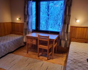 阿卡斯洛姆波罗Mäntymajat的客房设有书桌和带床的窗户。